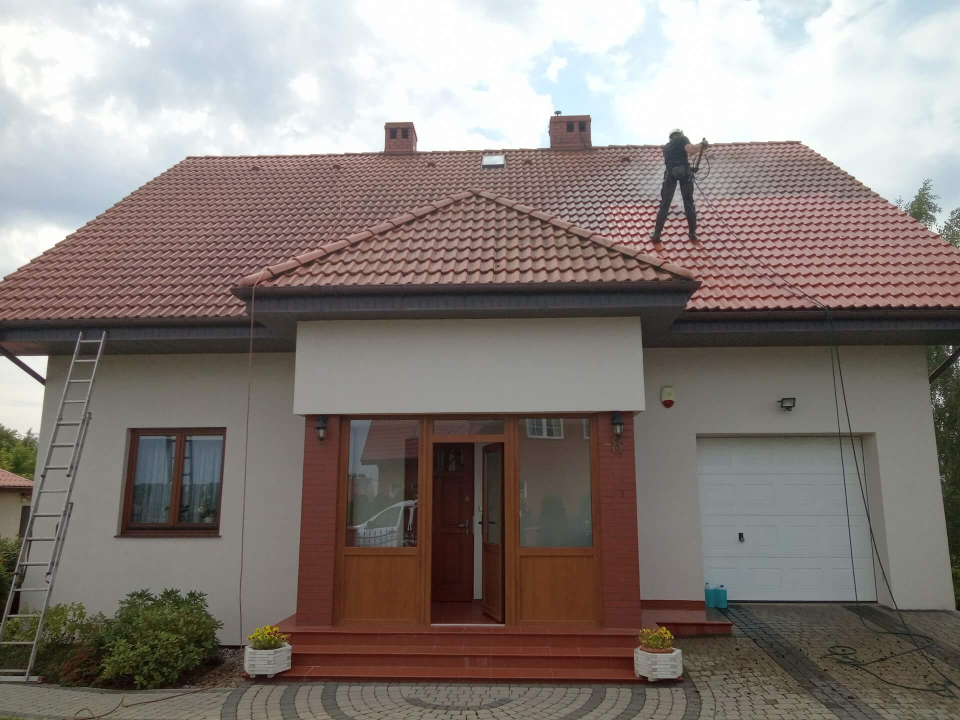 Prace wysokościowe przy myciu dachu domu jednorodzinnego