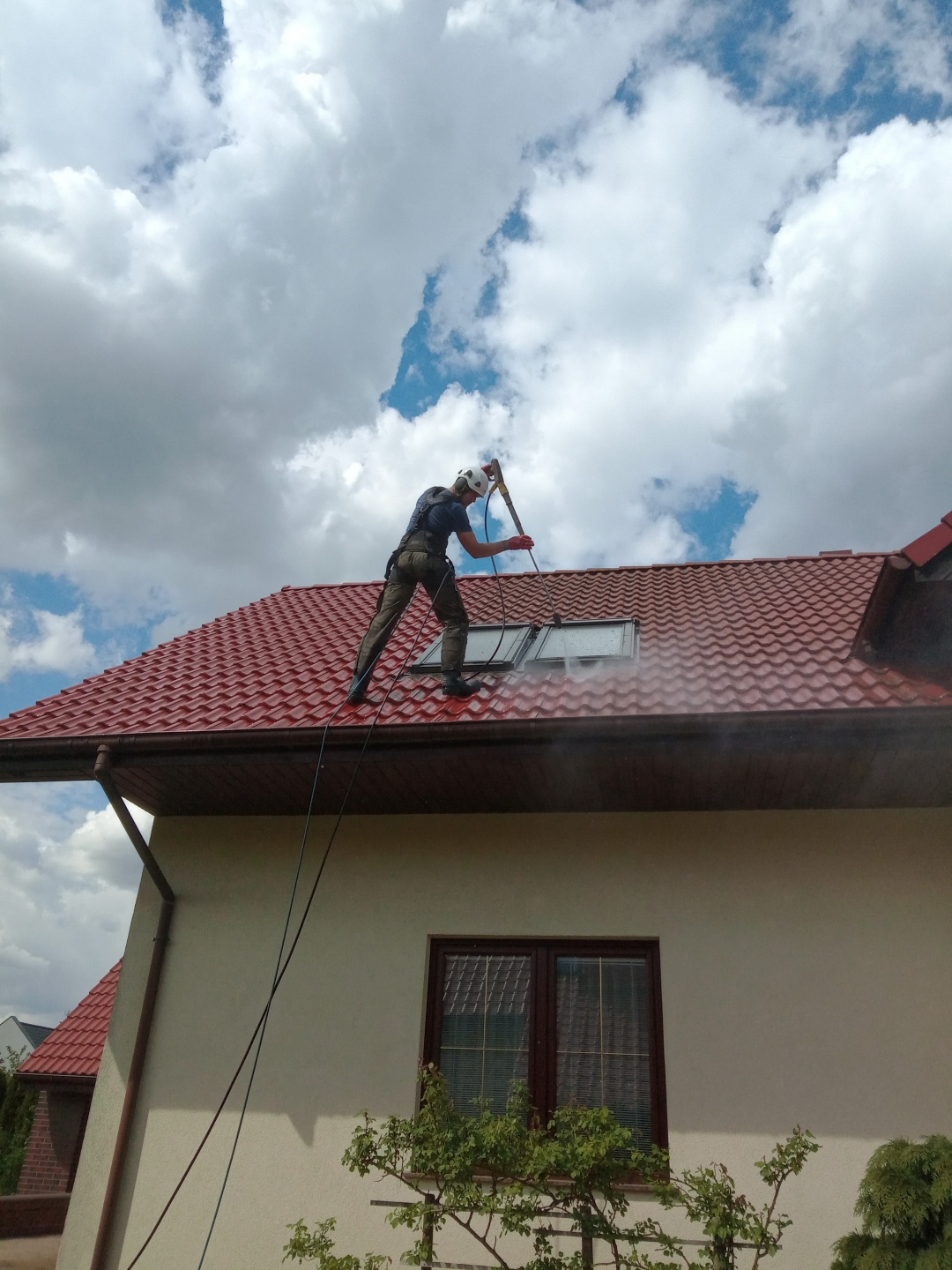 Pracownik az clean- alpinistyczne mycie dachu z dachówki ceramicznej z myjka ciśnieniowa