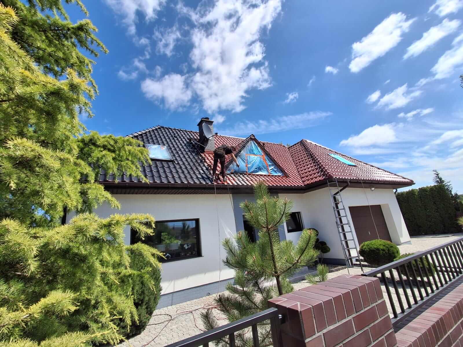 pracownik az clean maluje dach domu