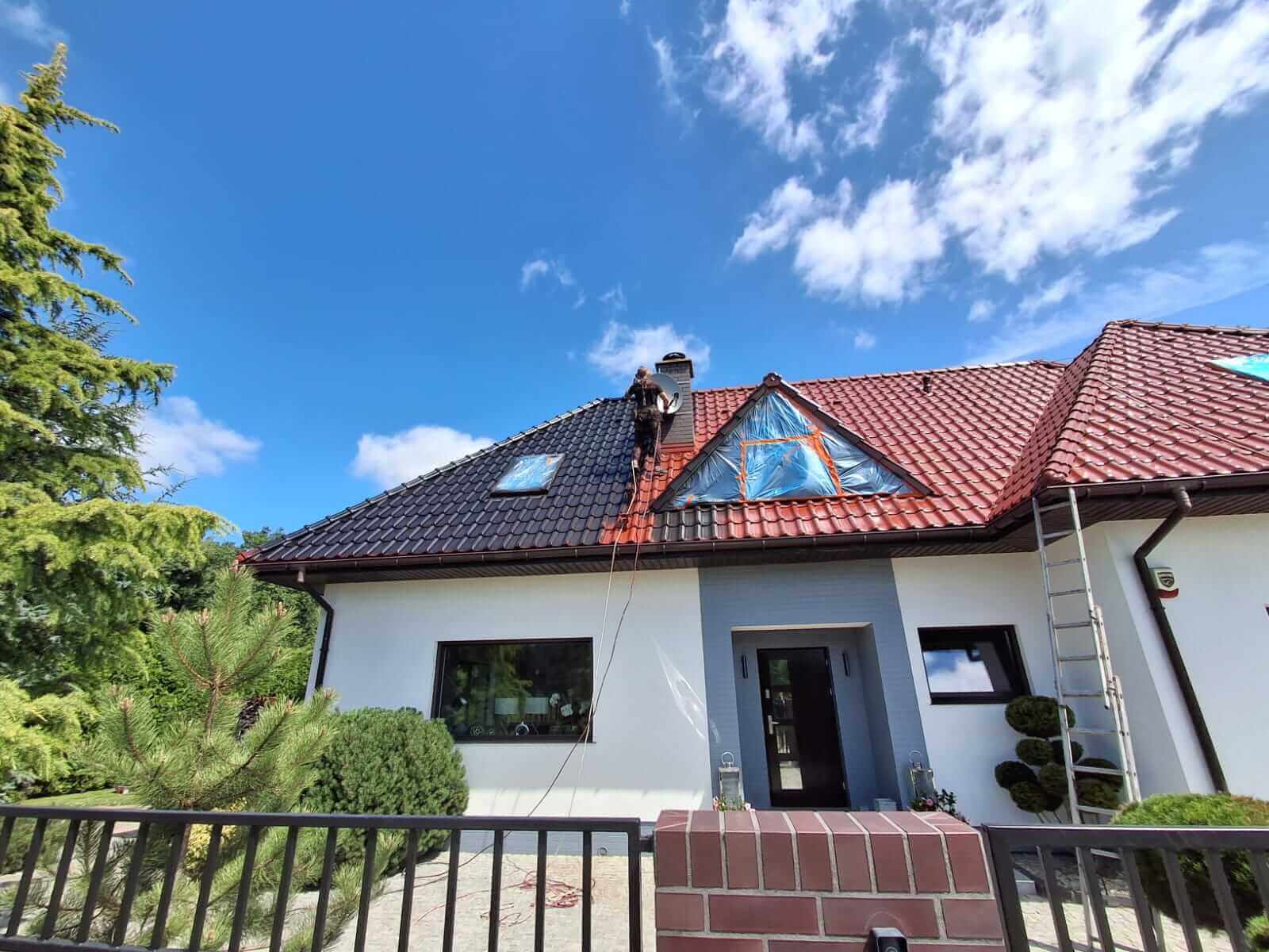 pracownik-az clean-maluje dach- domuku jednorodzinnego