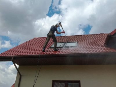 Pracownik az clean- alpinistyczne mycie dachu z dachówki ceramicznej z myjka ciśnieniowa